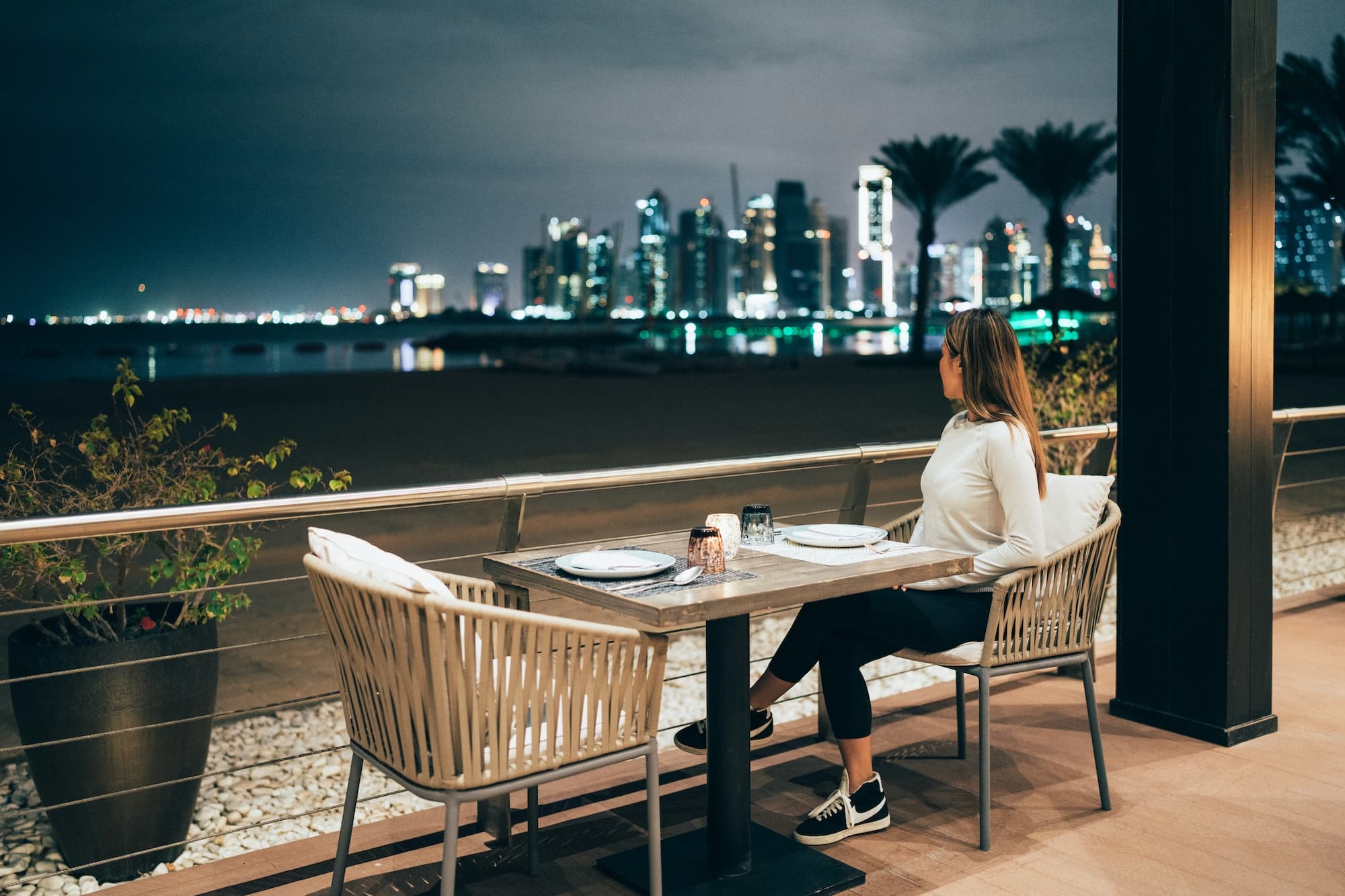 A person enjoying a quiet meal alone at a plant-filled cafe window